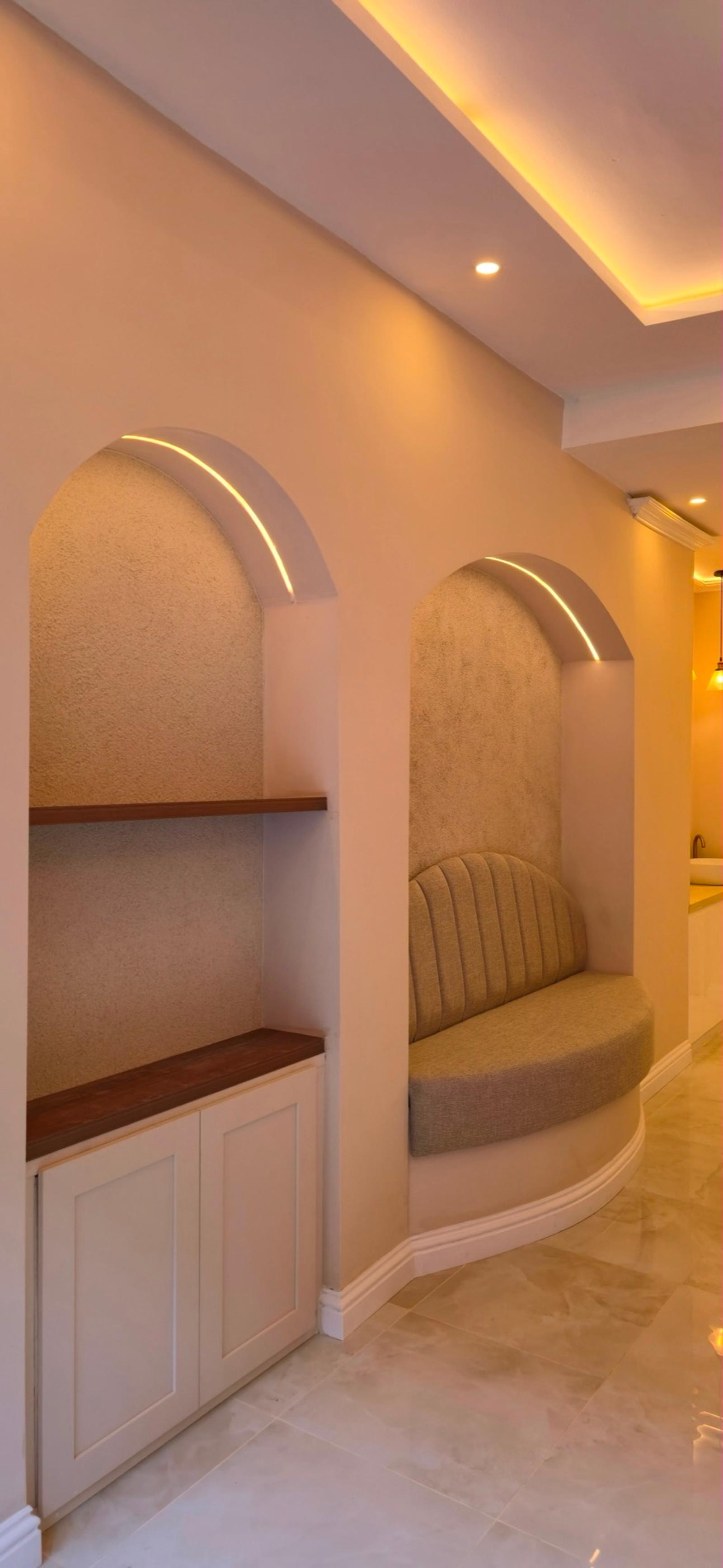 Two cream fluted arch niches with shelves and a suede scallop-backed seat