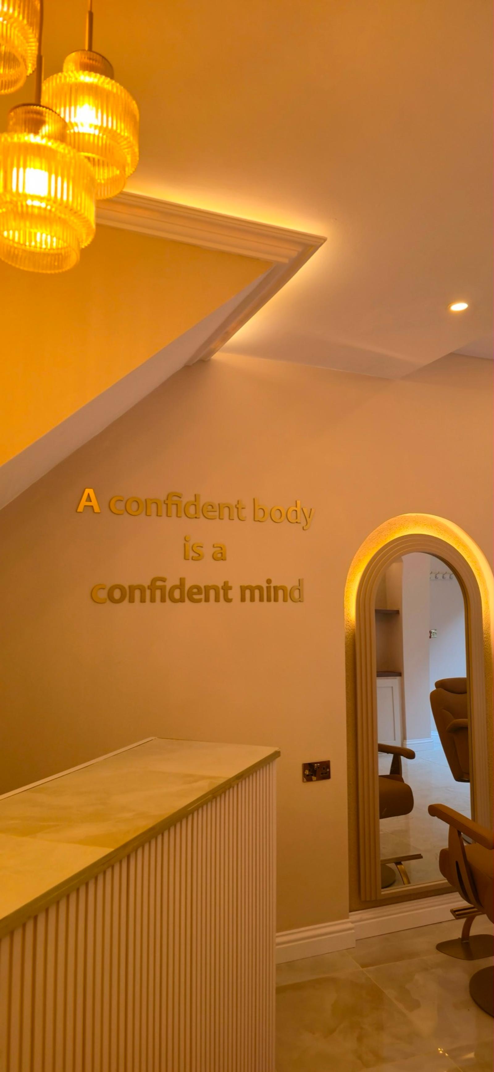 Gold lettering reading 'A confident body is a confident mind'