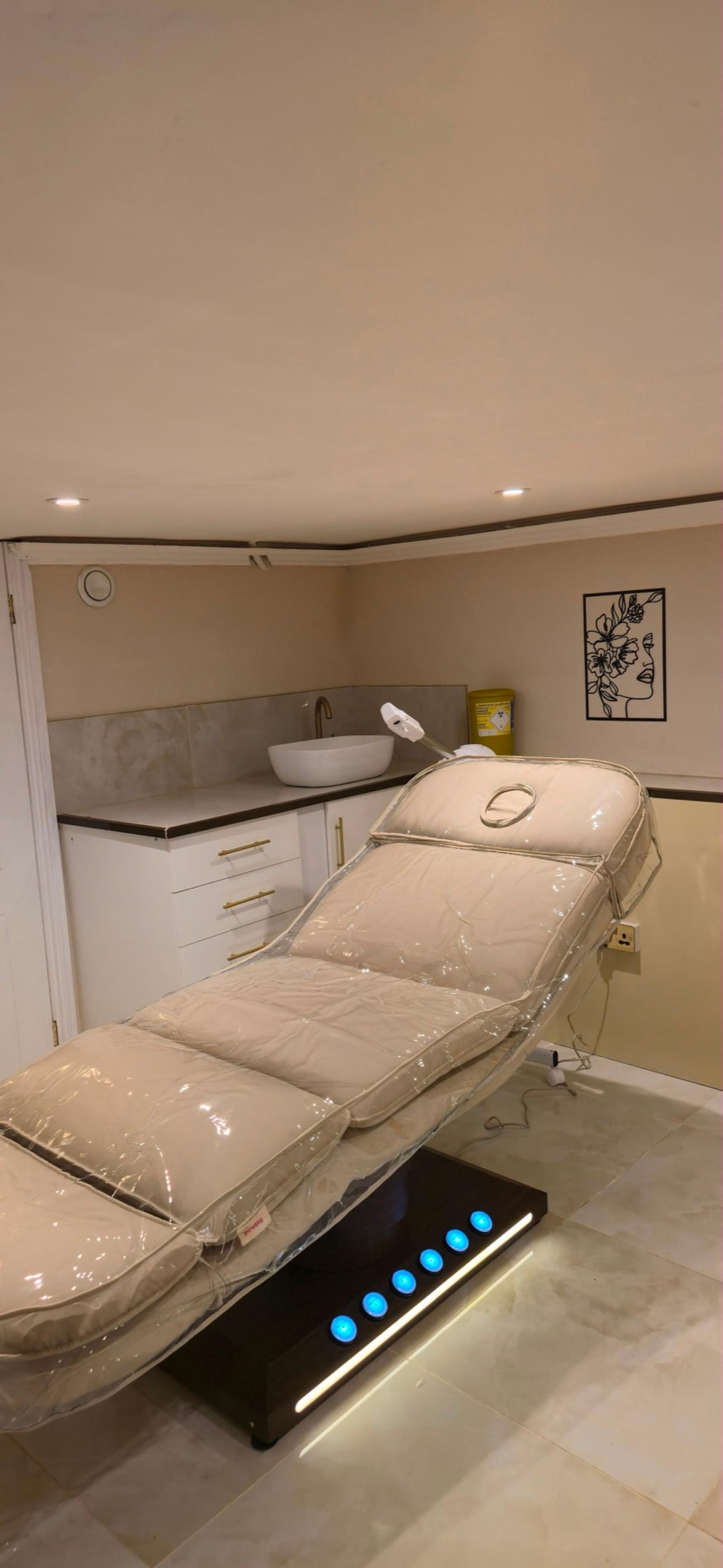 A cream treatment chair, sink and cabinets in the Gazals treatment room